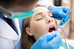 Woman with eyes closed receiving dental treatment