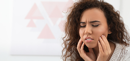 Woman holding jaw in pain